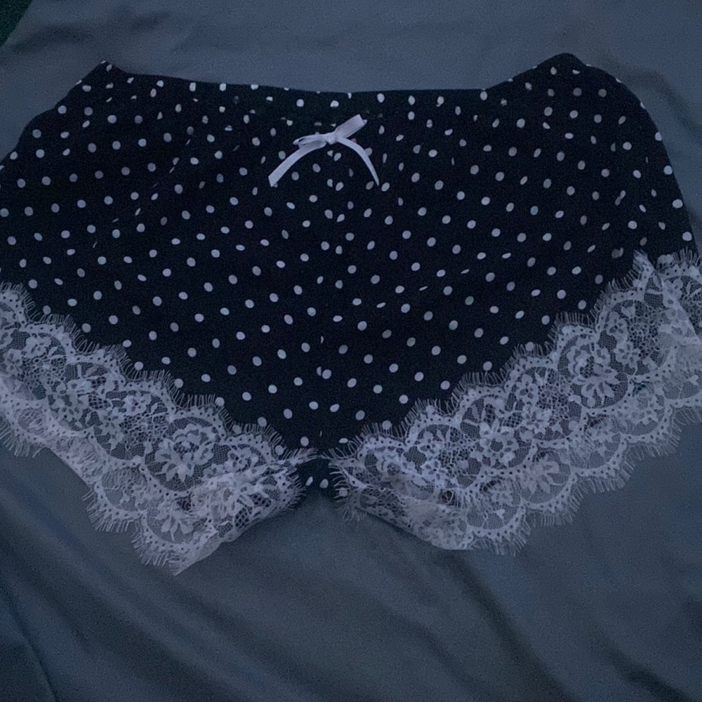 These are polka dotted black pajama shorts with lace at the thigh